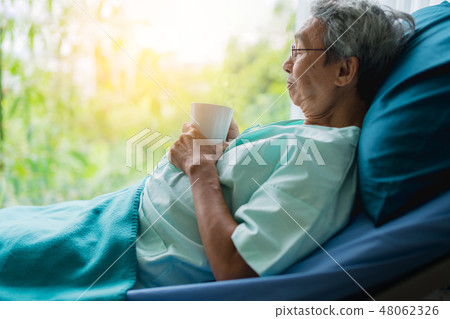 asian senior patient man take a rest with hot tea 48062326