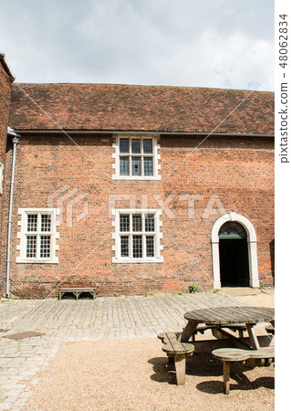 Building of red brick and round table made of wood In the outskirts of England Building of red brick and round table made of wood In the outskirts of England 48062834