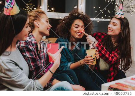 Happy females joking at party with holiday attributes 48063785