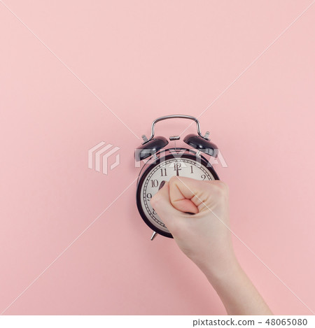 Female hand with alarm clock. Morning concept Female hand with alarm clock. Morning concept 48065080