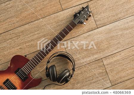 Guitar recording. An electric guitar and professional headphones on a wooden floor 48066369