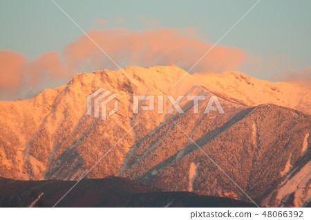 The figure of the Yatsugatake mountains reflected in the morning glow of the severe winter The figure of the Yatsugatake mountains reflected in the morning glow of the severe winter 48066392