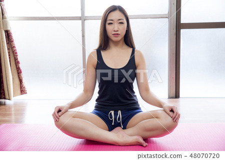 A woman sitting with a cage 48070720
