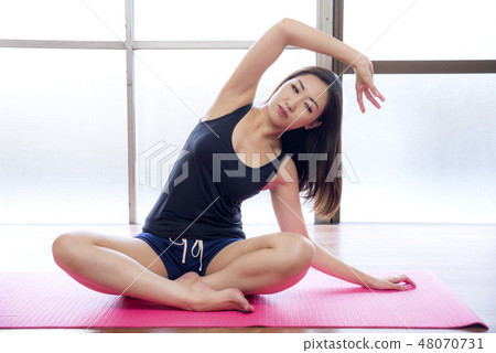 A woman sitting and stretching 48070731
