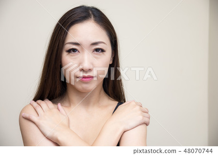 一名婦女用她的在她的肩膀的手 一名婦女用她的在她的肩膀的手 48070744