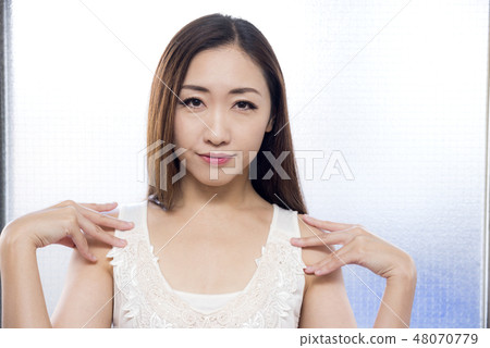 White one-piece lady touching shoulder with hand White one-piece lady touching shoulder with hand 48070779