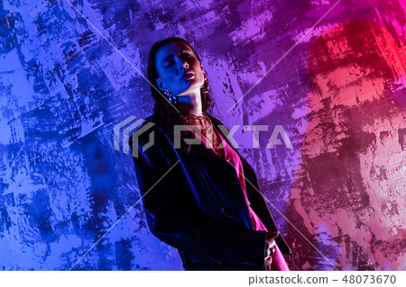 Beautiful elegant woman standing against colorful background 48073670