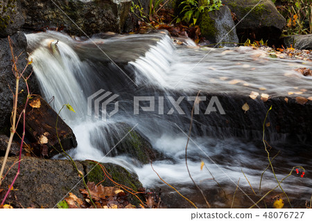 Water flowing over rocks in creek Water flowing over rocks in creek 48076727
