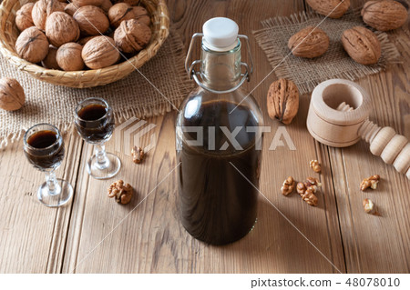 A bottle of homemade nut liqueur with walnuts A bottle of homemade nut liqueur with walnuts 48078010