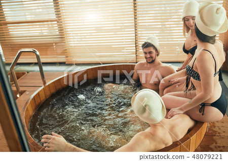 Group of caucasian diverse friends enjoying jacuzzi in hotel spa 48079221