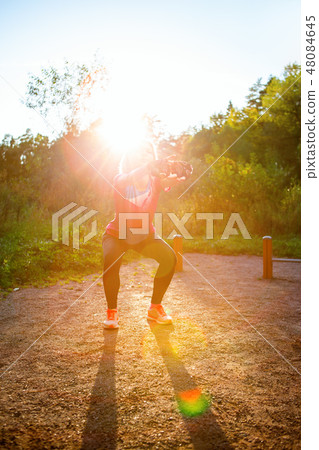 Photo of young girl stretching in summer park 48084645