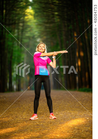 Image of young girl stretching in summer park 48084753