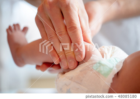 Photo of hands of massage therapist making foot massage to small child/ Photo of hands of massage therapist making foot massage to small child/ 48085180