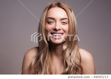 Adult beautiful blond woman with white veneers on the teeth. Adult beautiful blond woman with white veneers on the teeth. 48085213