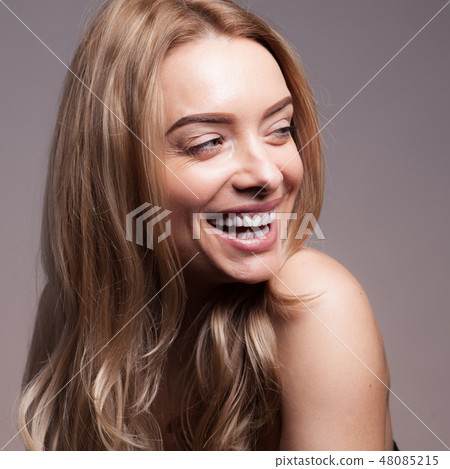 Adult beautiful blond woman with white veneers on the teeth. Adult beautiful blond woman with white veneers on the teeth. 48085215