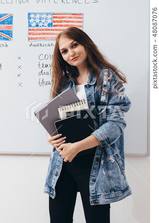 Female student with books in classroom English language school. 48087076