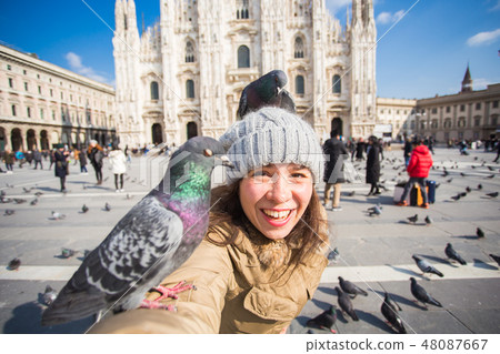 Italy, excursion and travel concept - young funny woman taking selfie with pigeons in front of 48087667