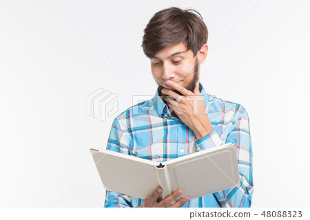Education, leisure and people concept - young beard man reading a book and surprised Education, leisure and people concept - young beard man reading a book and surprised 48088323