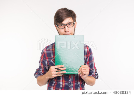 Education, student and business people concept - young man with file and pencil. Guy is shy and Education, student and business people concept - young man with file and pencil. Guy is shy and 48088324
