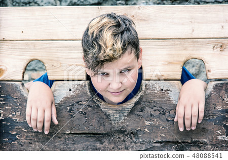 Young caucasian boy in medieval pillory 48088541