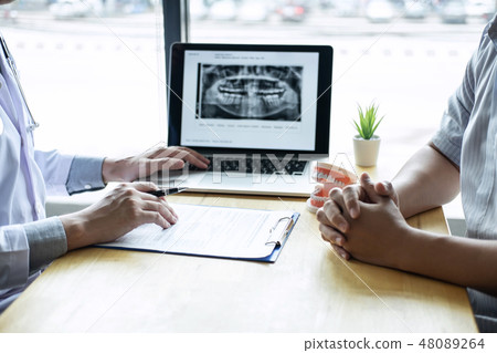 Image of doctor or dentist presenting with tooth x-ray film reco 48089264