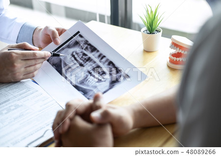 Image of doctor or dentist presenting with tooth x-ray film reco 48089266
