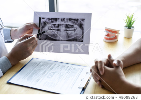 Image of doctor or dentist presenting with tooth x-ray film reco 48089268
