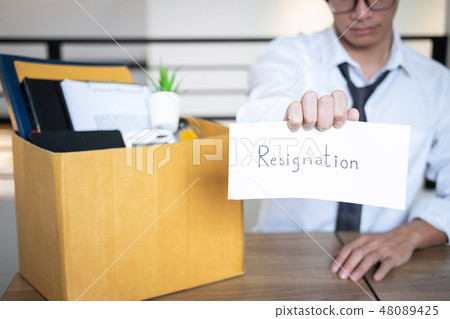 Stressed businessman will being resignation and packing belongin 48089425