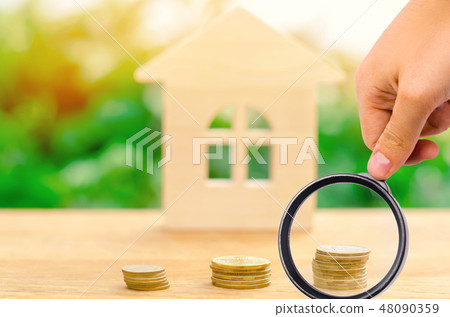 stack of coins and a wooden house 48090359