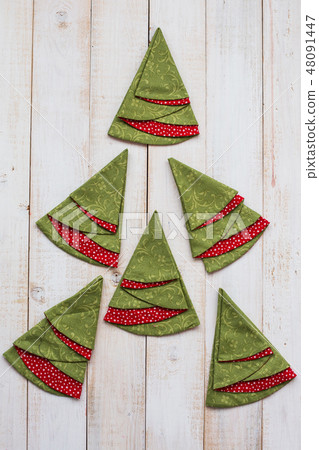 patchwork and quilting concept - macro of colorful decorative red-and-green napkins on a whitewashed 48091447