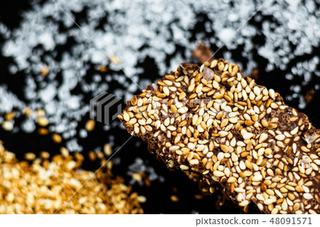 Luxury handmade dark chocolate with seasame and sea salt, black background Luxury handmade dark chocolate with seasame and sea salt, black background 48091571