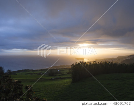 Aerial view of Vila Franca do Campo town volcanic islet during orange sunset with clouds, contre Aerial view of Vila Franca do Campo town volcanic islet during orange sunset with clouds, contre 48091762