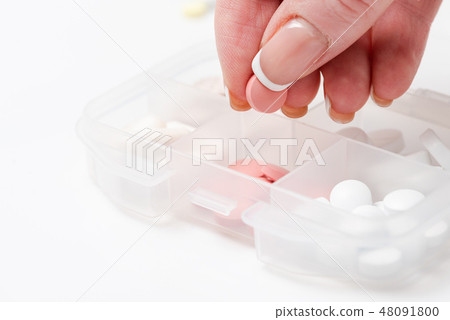 Close-up of female hand holding a pink pill Close-up of female hand holding a pink pill 48091800