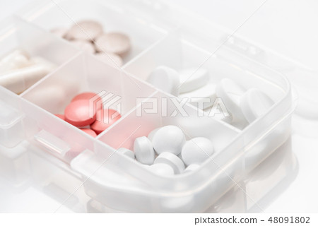 Close-up of drug box with various pills, capsules 48091802