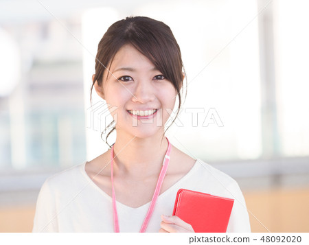 Business woman smiling with a red notebook 48092020