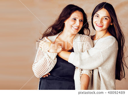 cute pretty teen daughter with mature mother hugging, fashion style brunette makeup close up tann cute pretty teen daughter with mature mother hugging, fashion style brunette makeup close up tann 48092489