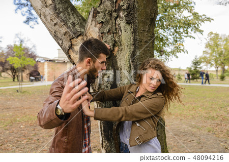 Young couple showing anger in the public park Young couple showing anger in the public park 48094216