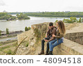 Young couple using their mobile phone near river 48094518