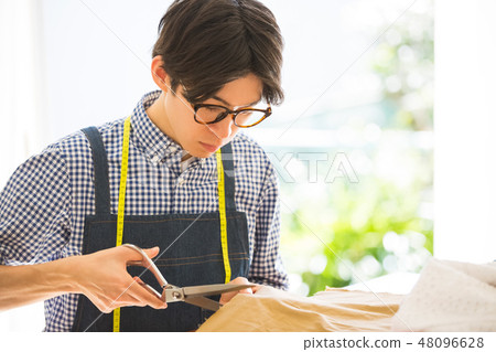 A man sewing 48096628