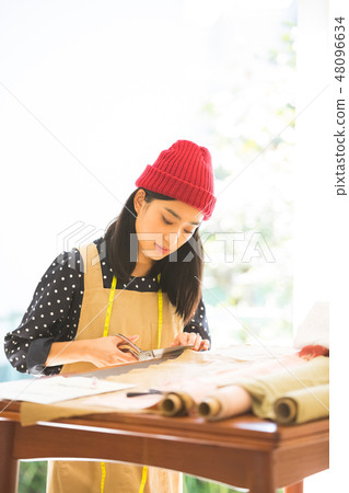 A woman sewing A woman sewing 48096634