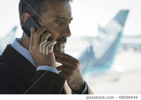 在國外商務旅行的一個商人叫在機場 48096649