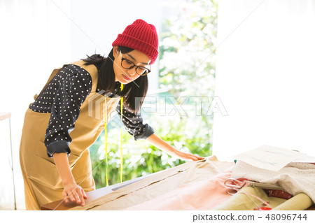 A woman sewing 48096744