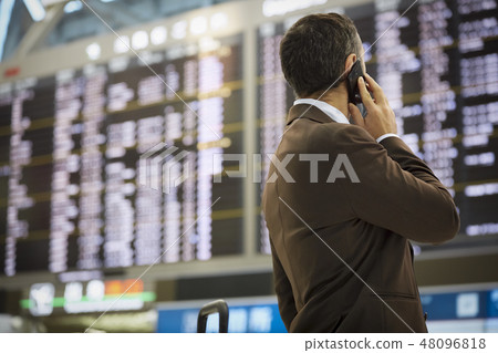 在國外商務旅行的一個商人叫在機場 48096818