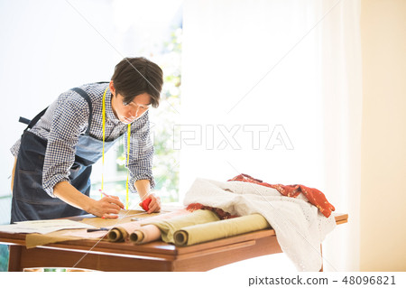 A man sewing 48096821