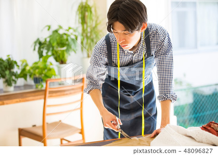 A man sewing 48096827