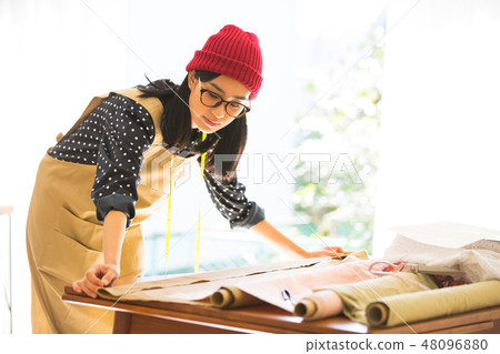 A woman sewing 48096880