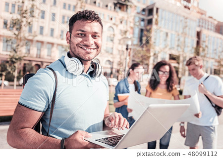 Positive delighted man using his laptop 48099112