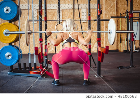 girl squats with a barbell girl squats with a barbell 48100568