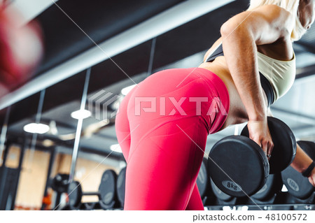 the girl is engaged with dumbbells the girl is engaged with dumbbells 48100572