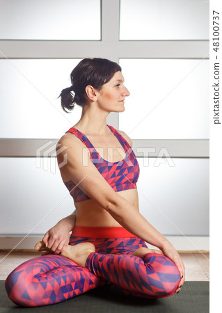 Young sporty woman doing Padmasana exercise 48100737
